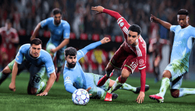 A football player in a red kit is challenged by multiple defenders in blue during an intense match, with one player making a slide tackle for the ball.